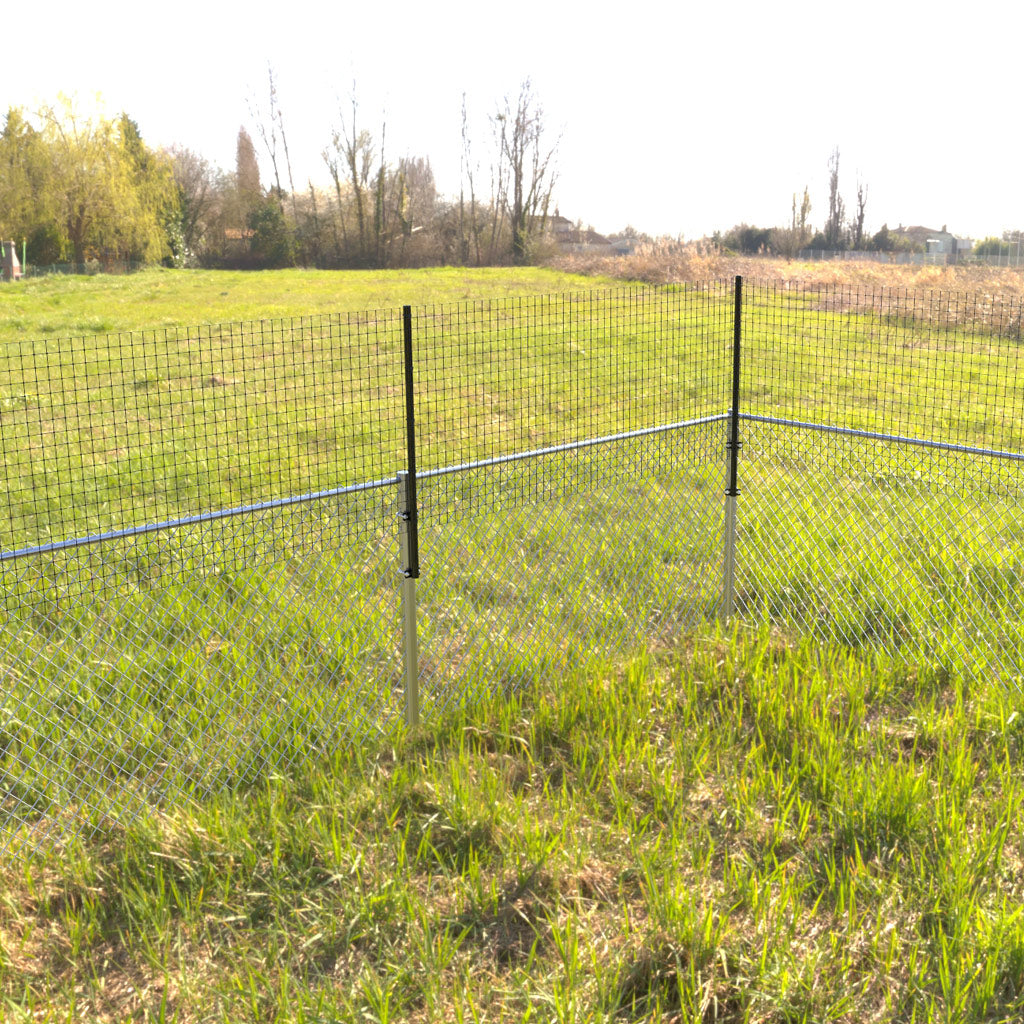 Dog Proofer&#39;s straight dog arm fence extension set up in a yard with grass.
